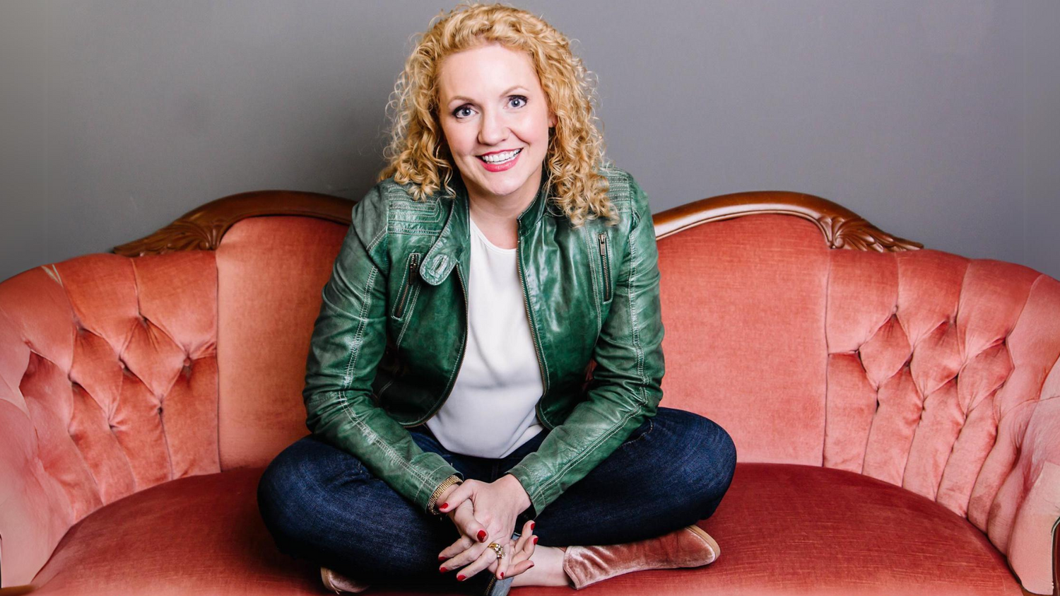Alli Worthington sitting on a red couch talking about anxiety and imposter syndrome