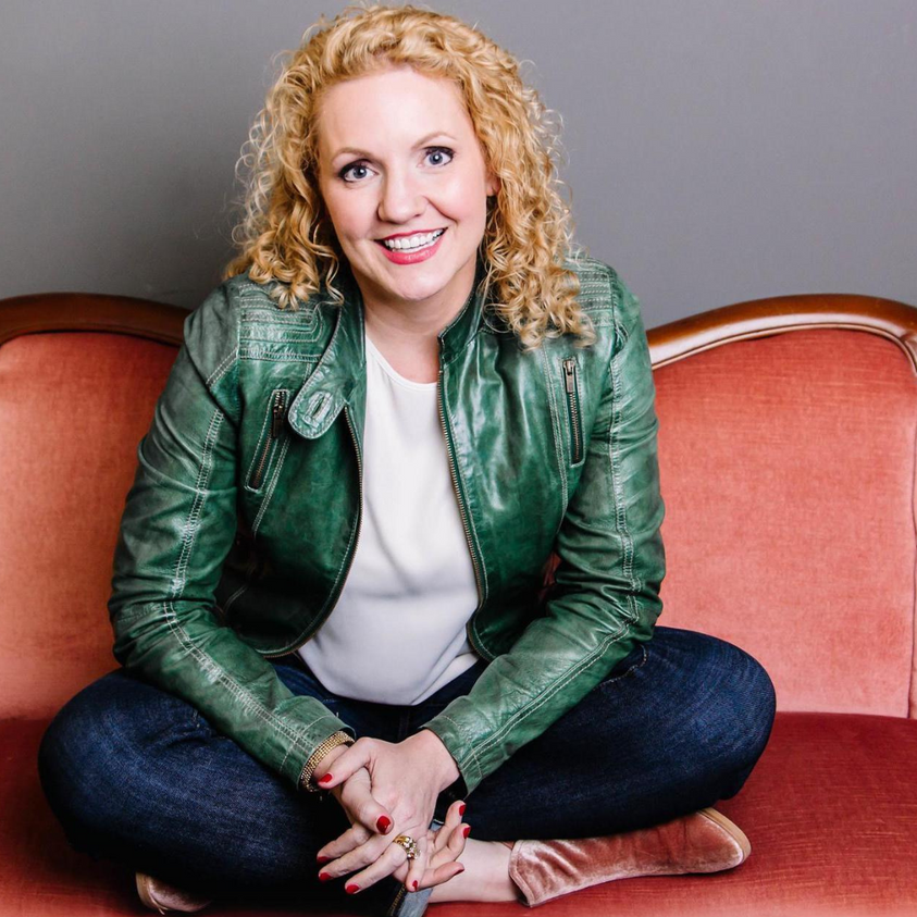 Alli Worthington sitting on a red couch talking about anxiety and imposter syndrome